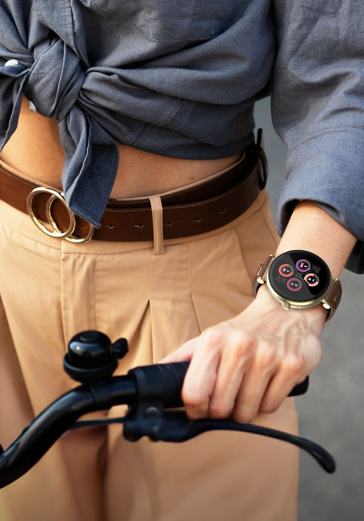 Person holding bicycle handlebars with a smartwatch on wrist